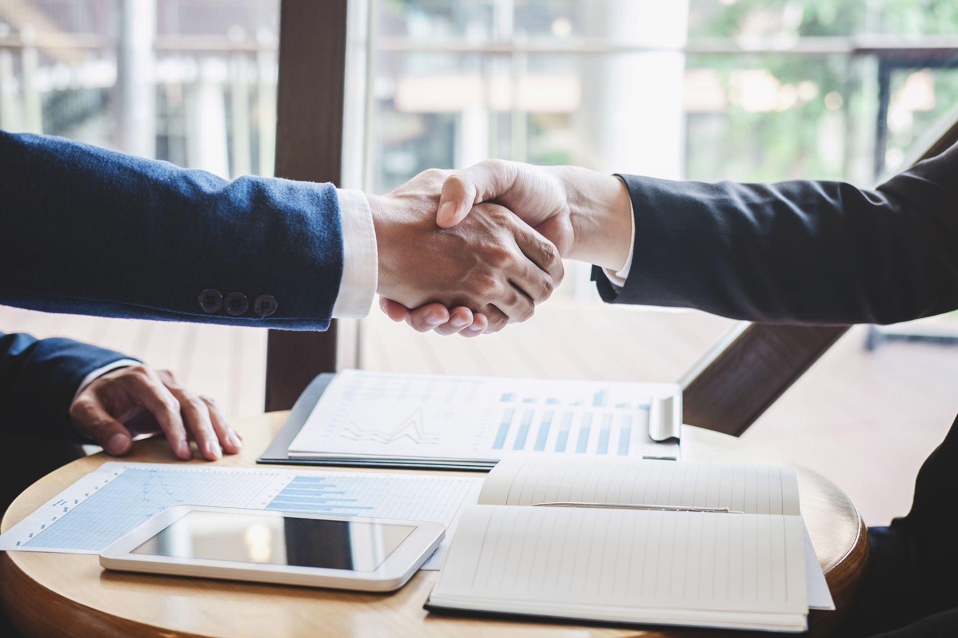 Finishing up a meeting, handshake of two happy business people after contract agreement to become a partner, collaborative teamwork. Finishing up a meeting, handshake of two happy business people after contract agreement to become a partner, collaborative teamwork.